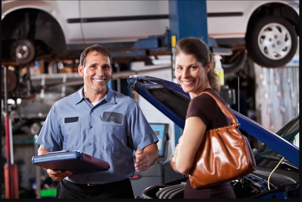 Select German Car Service technician explaining a repair to a customer