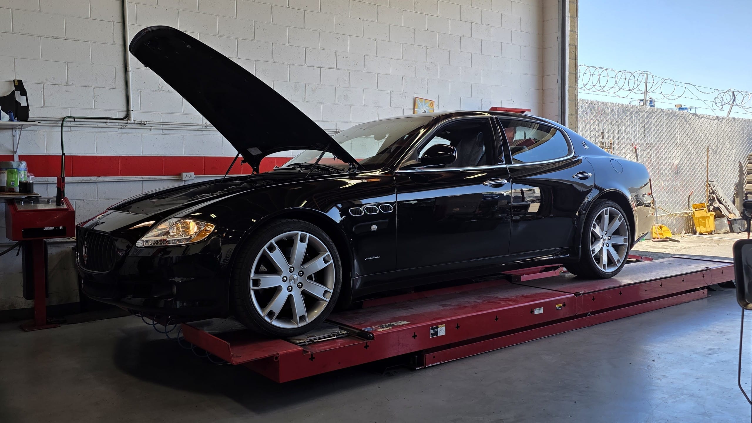 20250630_120147 Black Maserati sedan with the hood open on a lift at Select German Car Service